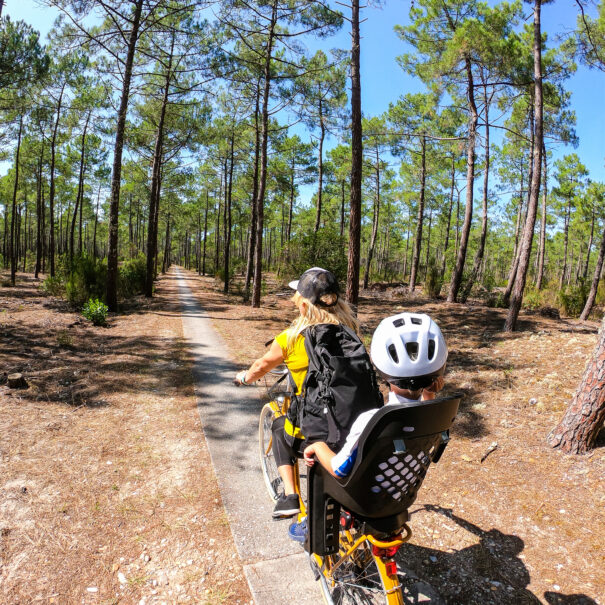 Mother and son cycling through the forest from Lacanau Ocean to Lacanau Lake in France, Europe. GoPro.